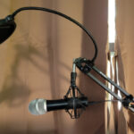 Image of a black studio microphone against a brown curtain
