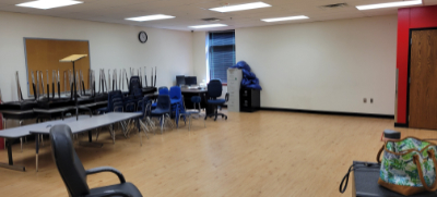 A wide shot of a school classroom with desks and chairs stacked along one wall. | Science Under Scrutiny – A Closer Look At Junk Science