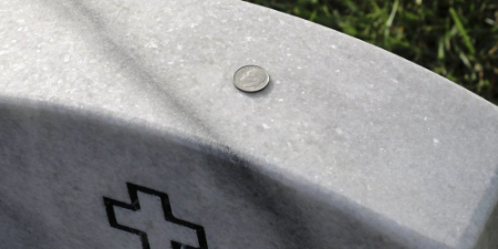 An image of a dime on a military headstone | A New Grandson, a Lost Friend, and an Exoneration